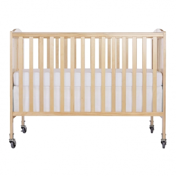 Dream On Me Folding Full Size Crib Dream On Me folding full size crib in natural wood finish with organic white fitted sheet set up in a bright vacation rental bedroom in St. Augustine Florida